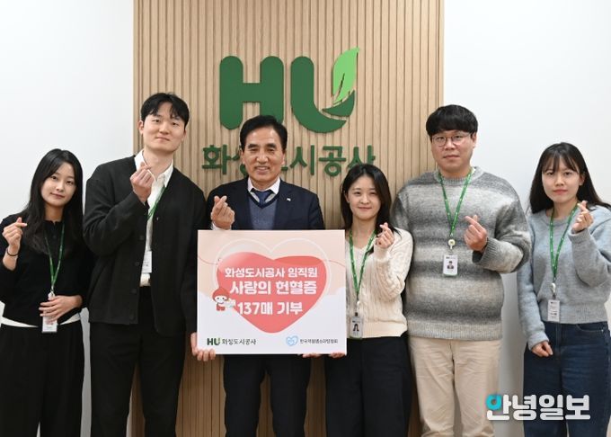 화성도시공사 한병홍 사장이 임직원들이 자발적으로 기부한 헌혈증 전달을 알리는 판넬을 들고 기념촬영을 하고 있다.