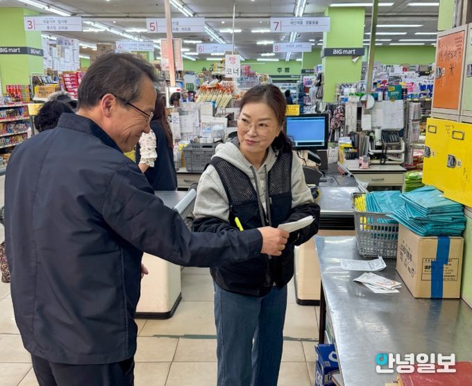 사장이 종량제봉투 주문 수량 확인 후 수령 확인증을 건네 받고 있는 모습